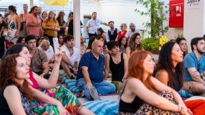 A diverse group enjoys a live music performance outdoors, capturing togetherness and cultural celebration.